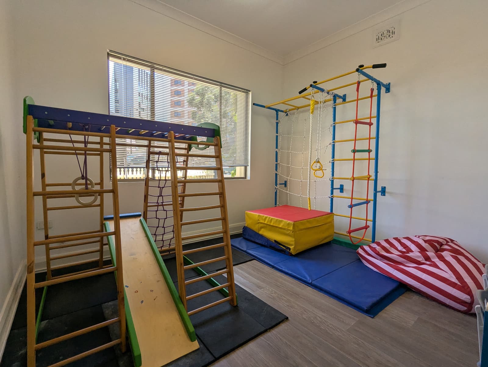 Indoor sensory gym with climbing frame, ladders and crash mats