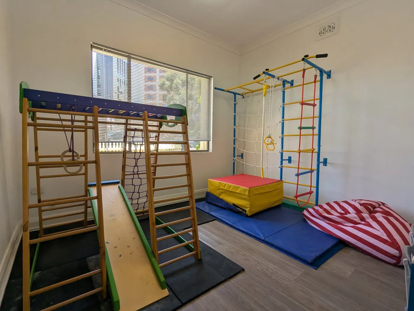 Indoor sensory gym with climbing frame, ladders and crash mats