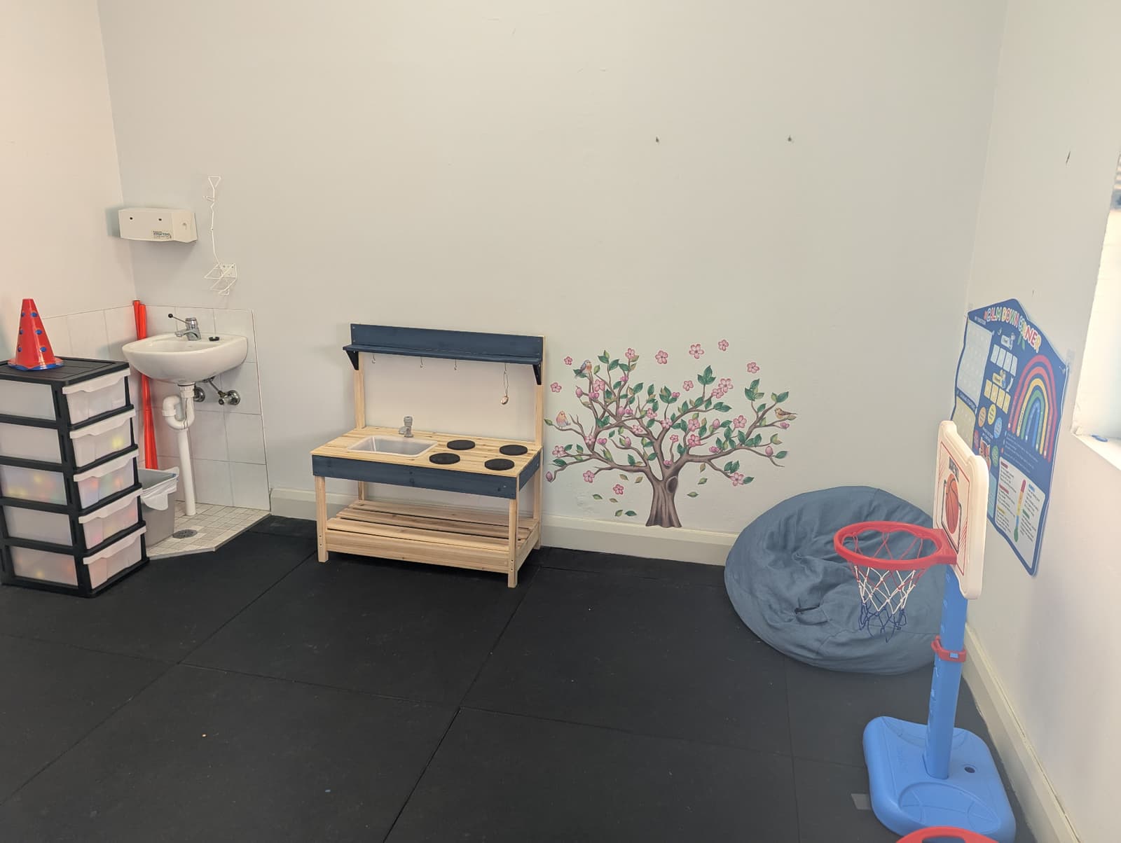 Play-based therapy room with mud kitchen and calm-down corner